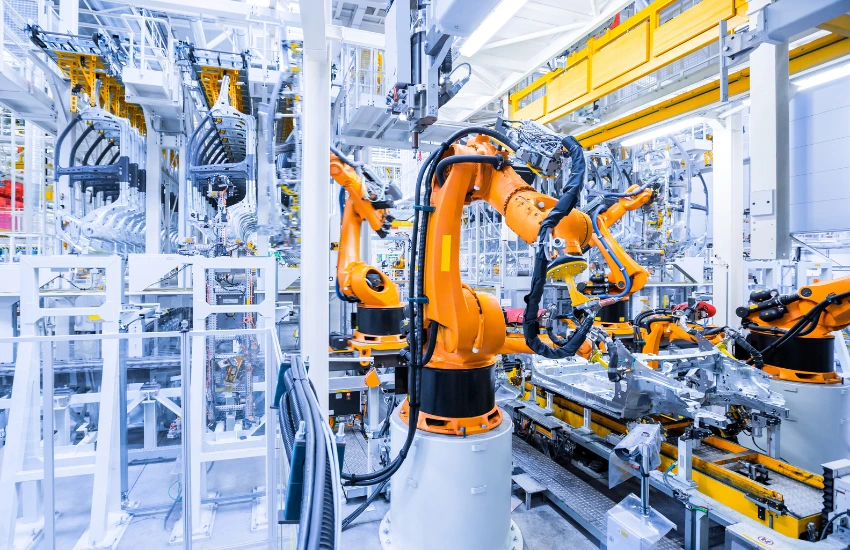 Brazo robótico integrando procesos con máquina CNC en una célula de producción automatizada