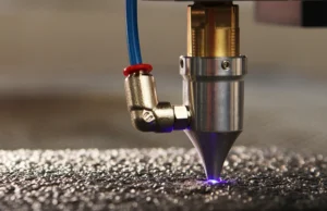 Corte Láser Metales Reflectantes Primer plano de un cabezal de láser de fibra GWLIKE cortando una placa de cobre con nitrógeno a alta presión.