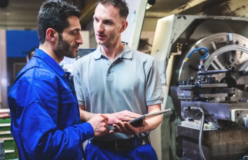 Operador revisando el husillo de un Router CNC para detectar fuentes de vibración mecánica.