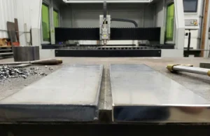 Comparativa de dos piezas de acero inoxidable: una cortada con oxígeno (borde oscuro) y otra con nitrógeno (borde brillante).